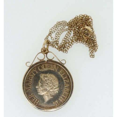 589 - A 9ct gold scroll top coin mount on a fine 9ct gold chain containing a 1977 Silver Jubilee medallion... 