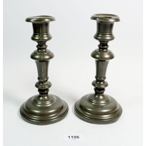 1106 - A pair of 18th century pewter candlesticks on wood, 20.5cm tall