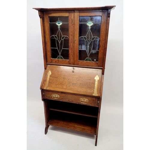 1128 - An oak Liberty Style Arts & Crafts small bureau with lead glazed doors inset vaseline glass flowers,... 