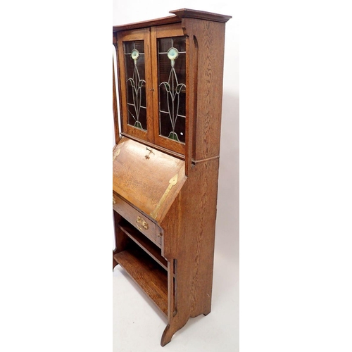 1128 - An oak Liberty Style Arts & Crafts small bureau with lead glazed doors inset vaseline glass flowers,... 