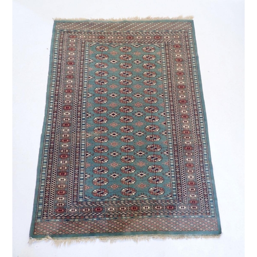 1148 - A Turkoman rug with multiple guls on a green ground 178x128cm