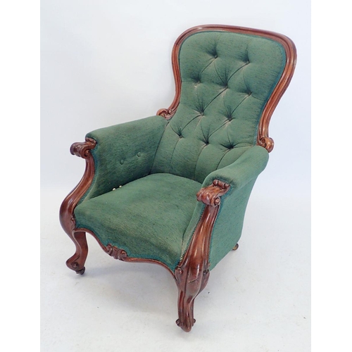 1150 - A Victorian green button upholstered armchair with mahogany frame, carved scroll arms and supports