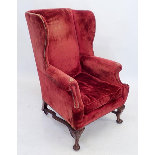 1153 - A George I style wing armchair with cabriole supports united by flat stretchers