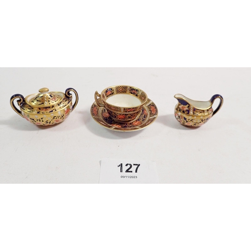 127 - A Royal Crown Derby miniature covered sugar bowl, jug and teacup, 3cm tall, tiny chip to rim of sauc... 