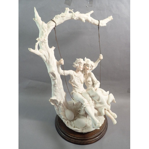 22 - A large Capodimonte bisque figure of a couple on a swing, 43cm tall