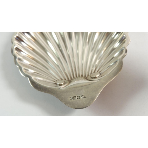 298 - A silver shell butter dish, Sheffield 1910 by Harrison Brothers & Howson, 60g and a silver candlesti... 