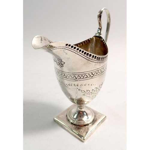 321 - A Georgian helmet-shaped silver cream jug with swagged floral decoration and initial to central shie... 