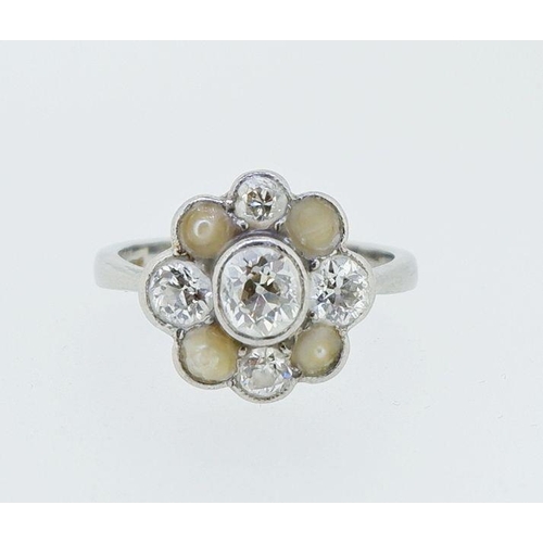 392 - A platinum set diamond and pearl cluster ring, the central diamond approx 0.5 carats, size M, the pl... 