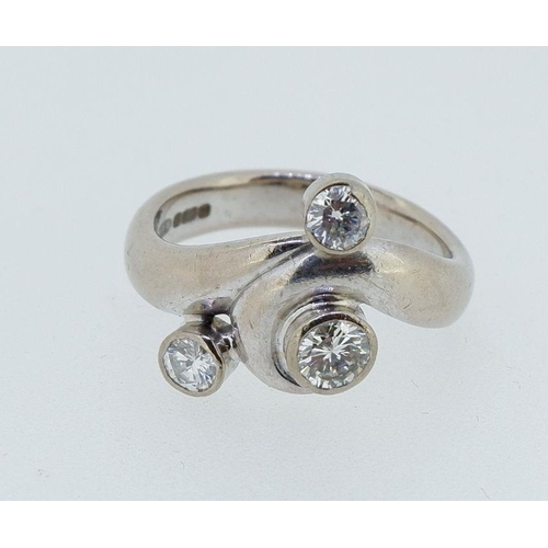 395 - A privately commissioned 18 carat white gold ring with three inclusion set diamonds in scrollwork as... 