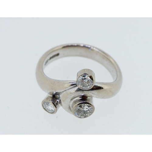 395 - A privately commissioned 18 carat white gold ring with three inclusion set diamonds in scrollwork as... 