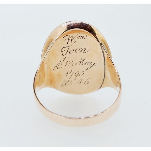 398 - A George III gold mourning ring with enamel oval surround to encapsulated embroidered fabric (possib... 