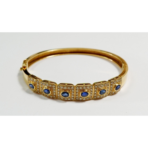 425 - An 18 carat gold hinged bangle with six square panels set sapphires within diamond surround, total w... 