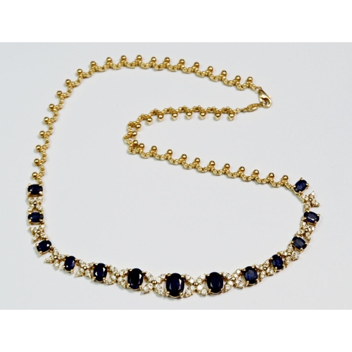 426 - A 14k gold necklace set thirteen graduated sapphires interspersed with diamond crosses, on fancy lin... 