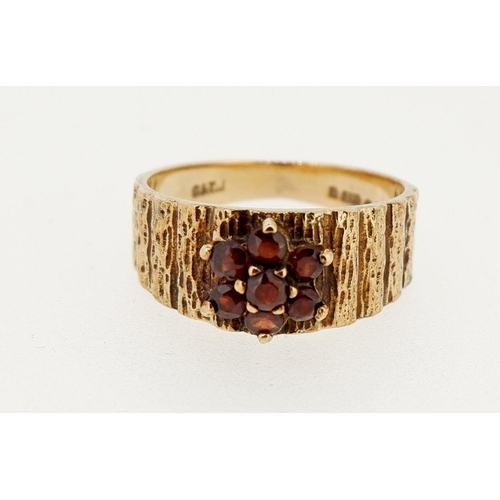 453 - A vintage 9 carat gold garnet cluster ring on textured band, size M to N, 3.7g