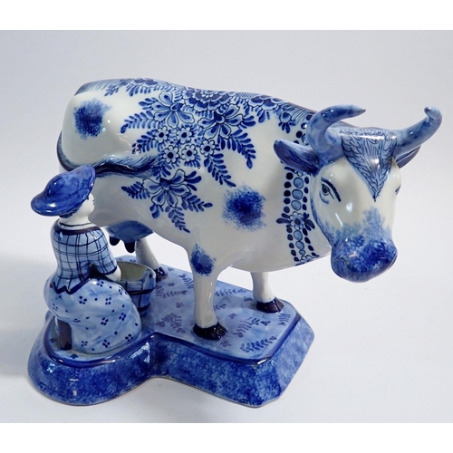 49 - A Faience blue and white cow and milkmaid, marked KB, 17.5cm tall
