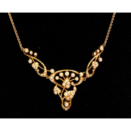 494 - An Edwardian Art Nouveau 15 carat gold necklace set seed pearls in stylised flower, stem and foliage... 