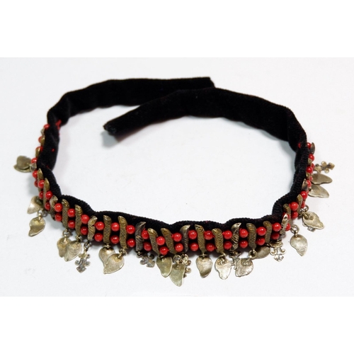 571 - A Middle Eastern vintage red bead, white metal and gilt metal choker necklace on velvet ribbon