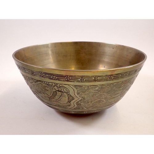 751 - A Chinese brass bowl decorated dragon and waves, cast mark to base, 24cm