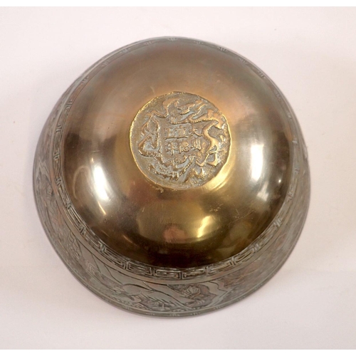 751 - A Chinese brass bowl decorated dragon and waves, cast mark to base, 24cm