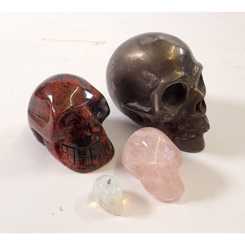 798A - Two stone carved skulls, a metal one and a moonstone pendant skull, largest 6.5cm