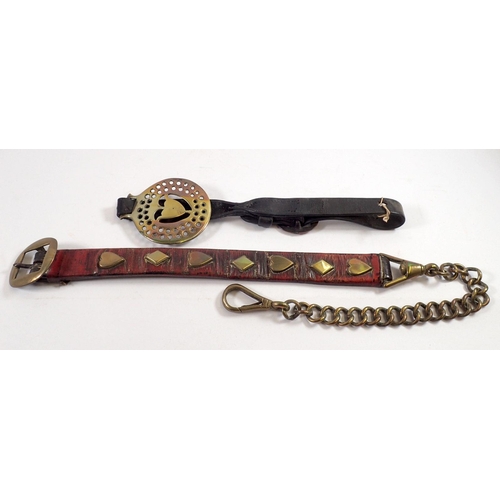 812 - An antique horse brass on leather strap and a red leather strap with heart and lozenge decoration