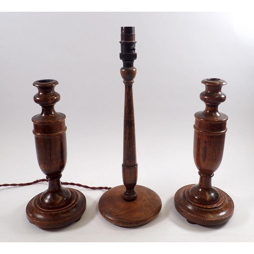 821 - A pair of oak candlesticks, 29cm tall and a turned wood table lamp, 38cm tall