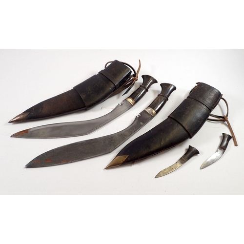 844 - Two horn handled Gurkha kukri knives in leather sheaths, one with two smaller knives, one missing a ... 