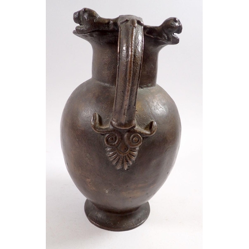 867 - A 19th century bronze jug in Roman style with lions head and anthemon leaf handle, 25cm tall