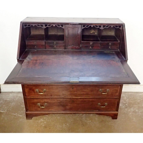 873 - A Georgian mahogany bureau with slope front and fitted interior over two short and three long drawer... 