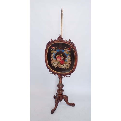 902 - A Victorian walnut shield form pole screen on elaborately carved column and triple cabriole base, th... 