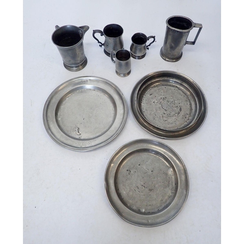 907 - A group of antique pewter including jug, two plates, three tankards and a one litre measure, some wi... 