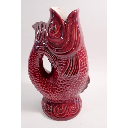 91 - A large red fish guggle jug, 30cm tall