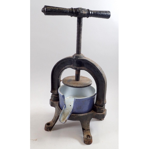 925 - A cast iron fruit press with blue enamelled iron bowl