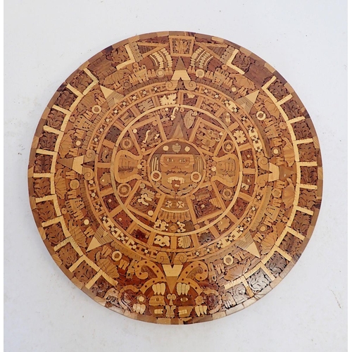 928 - A marquetry Aztec calendar with paperwork, 53.5cm diameter