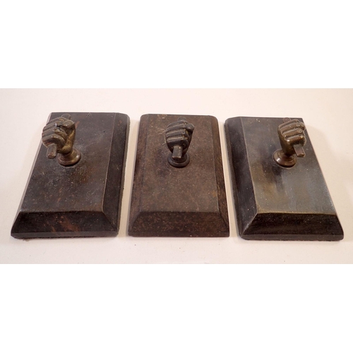 972 - A set of three bronze and cast iron fist form paperweights, 11 x 7cm