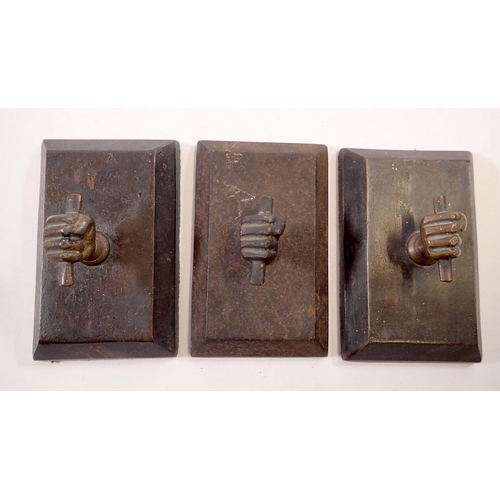 972 - A set of three bronze and cast iron fist form paperweights, 11 x 7cm