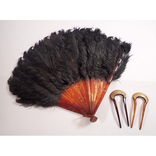 982 - A pair of tortoiseshell and gilt metal hair combs, 11.5cm and a faux tortoiseshell and ostrich feath... 