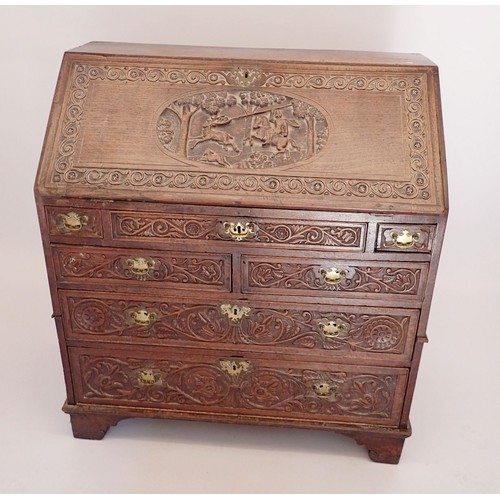 933 - An early 18th century bureau with all over finely carved decoration including hunting scene, foliage... 