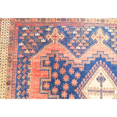 1091 - A large Persian rug with geometric and floral design on a pink ground, 214 x 162cm