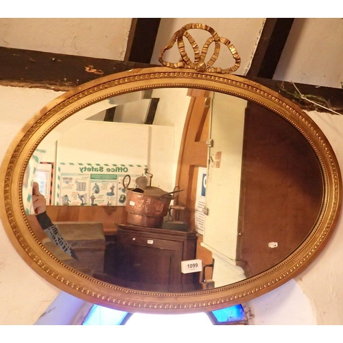 1099 - An antique gilt plaster oval bevel edged mirror with ribbon surmount and moulded frame, 40 x 61cm