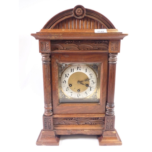 1148 - A Victorian walnut arch top architectural style mantel clock with pillar supports and silvered Art N... 