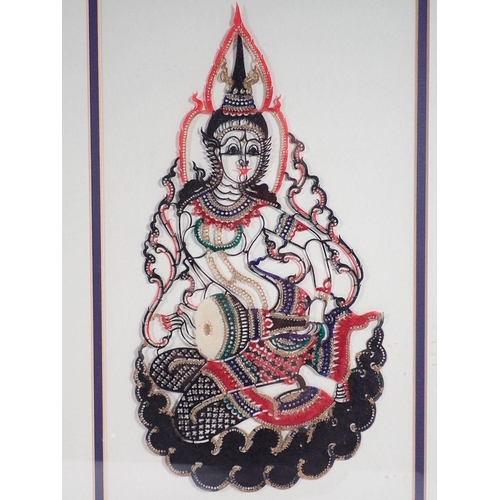 1186 - A pair of Thai painted and cut out leather picture of seated musicians, 32 x 18cm