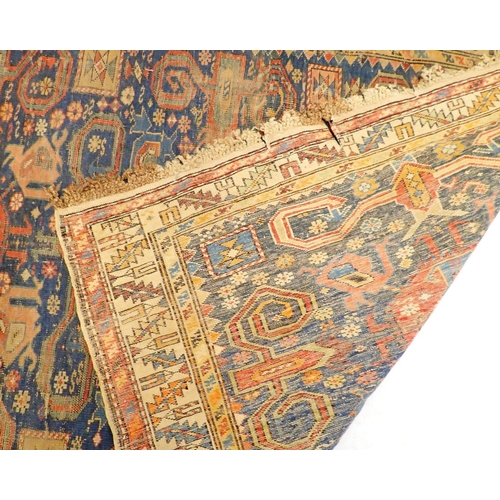 1313 - An antique Turkoman rug with multiple guls on a blue ground - in poor condition, 154 x 115cm