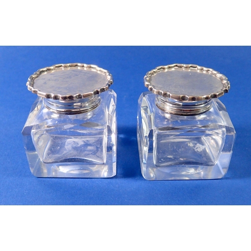 275 - Two cut glass inkwells with silver lids and collars, London 1902, base 5.5cm square x 6cm tall