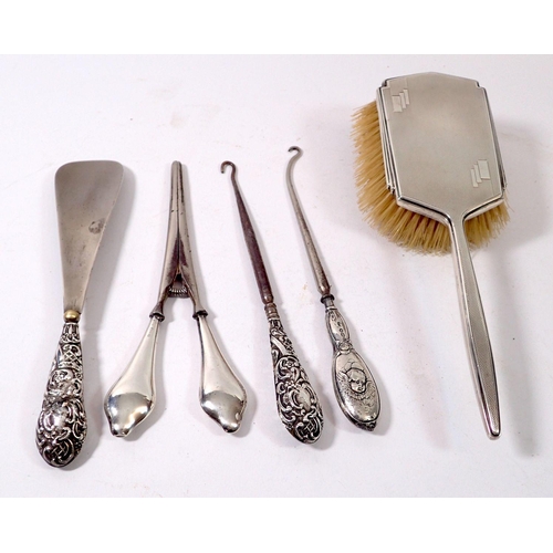 308 - A silver brush, two button hooks, shoe horn and glove stretchers