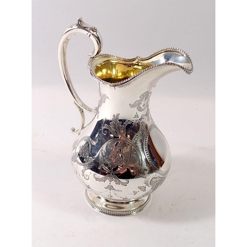 325 - A Victorian silver milk jug with engraved decoration, London 1860 by Barnards, 257g, 15cm tall