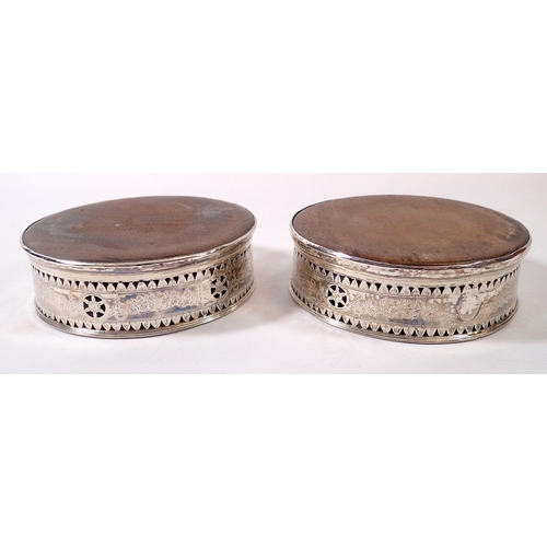 344 - A pair of Georgian silver bottle coasters with engraved and pierced decoration and wooden bases, mar... 