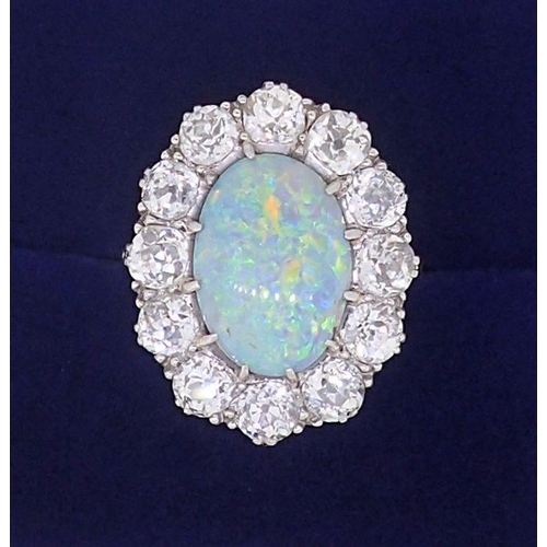 389 - A large platinum opal and diamond cluster ring, the opal 12mm x 9mm, the twelve brilliant cut diamon... 