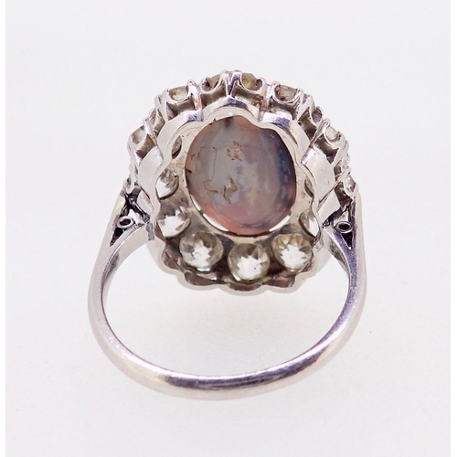 389 - A large platinum opal and diamond cluster ring, the opal 12mm x 9mm, the twelve brilliant cut diamon... 