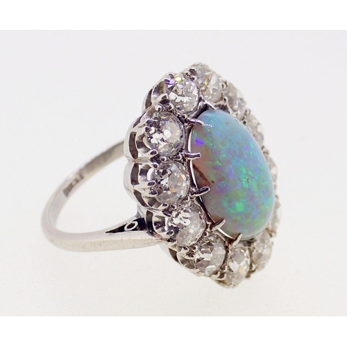 389 - A large platinum opal and diamond cluster ring, the opal 12mm x 9mm, the twelve brilliant cut diamon... 